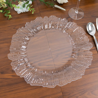 Clear decorative charger plate with a ruffled edge on a wooden table.