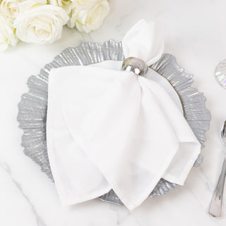 White napkin elegantly arranged on a silver decorative plate.