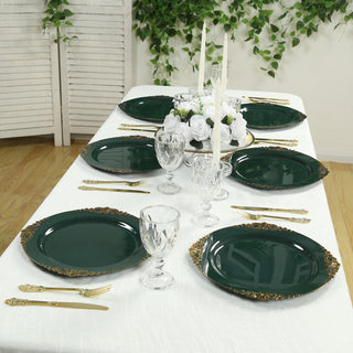 Elegant dark green dinner plates with gold accents on a beautifully set dining table.