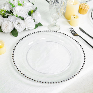 Clear charger plate with beaded rim on elegantly set dining table.
