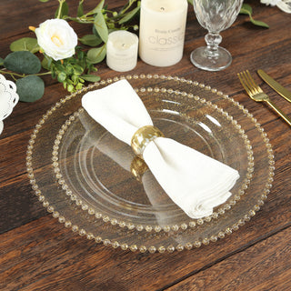 Elegant clear charger plate with gold beaded rim, styled with a napkin and ring.