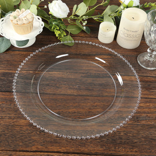Clear decorative plate with beaded edge on wooden table setting.