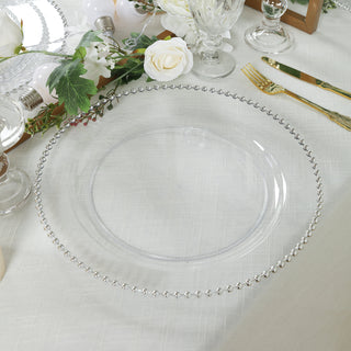 Clear charger plate with beaded rim on a beautifully set dining table.