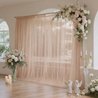 Pastel wedding backdrop with floral arch, candles, and elegant draped curtains