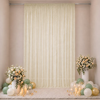Elegant cream curtain backdrop with floral arrangements and pastel balloons