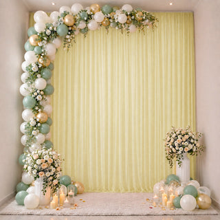 Elegant pastel balloon and floral party backdrop with candles and draped curtain