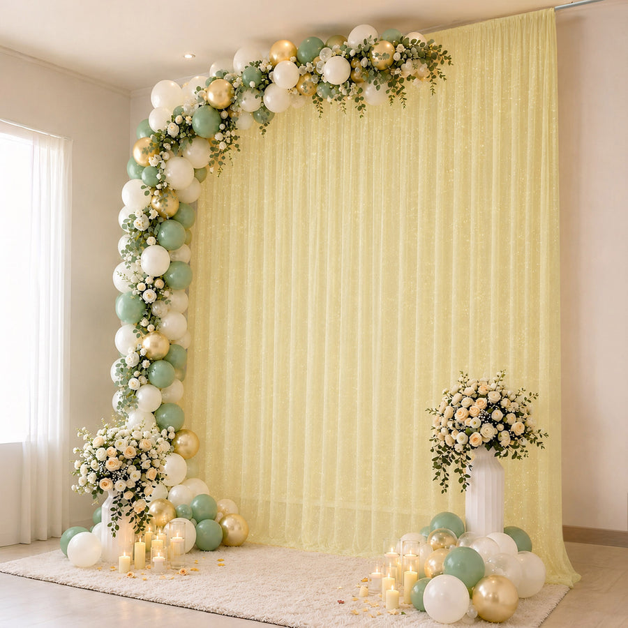 Elegant pastel balloon and floral event backdrop with candles and draped curtain