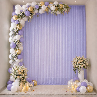 Lavender and gold balloon floral party backdrop with candles and draped curtain