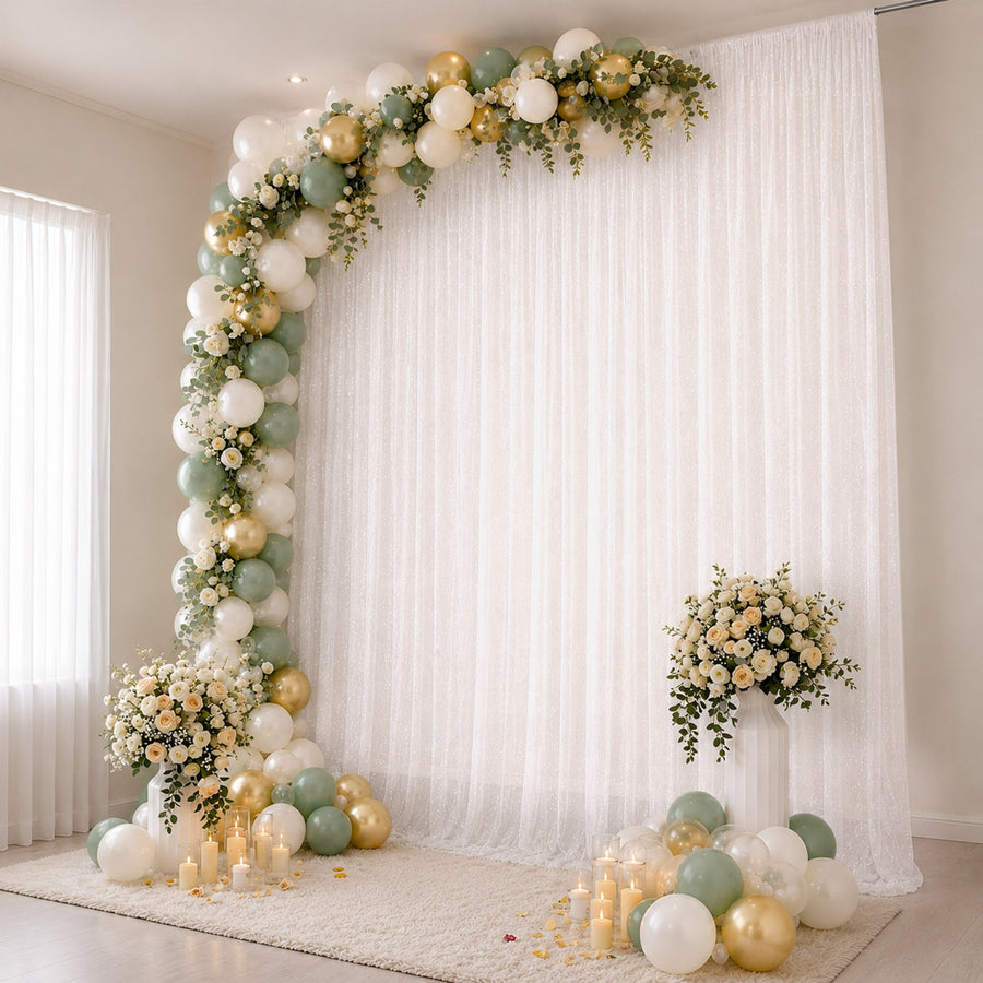 Elegant balloon and floral wedding backdrop with candles and draped white curtains