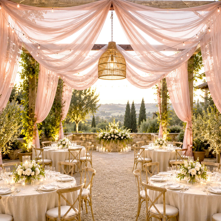 Elegant outdoor wedding reception with pink drapes, string lights, and scenic views