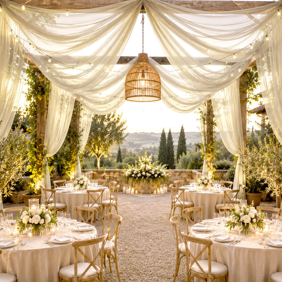 Elegant outdoor wedding reception with draped canopy, lantern, and floral tablescape