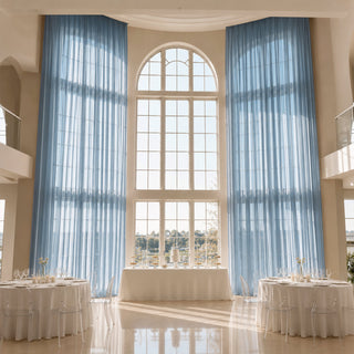 Elegant wedding reception hall with tall arched windows and blue drapes