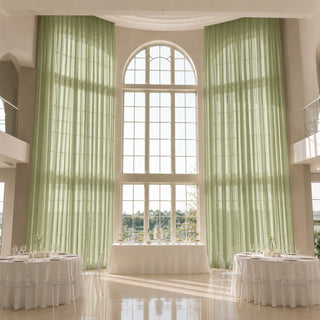Elegant wedding reception hall with tall arched windows and green drapes