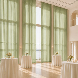 Elegant event hall with tall green curtains, round tables, and waterfront view