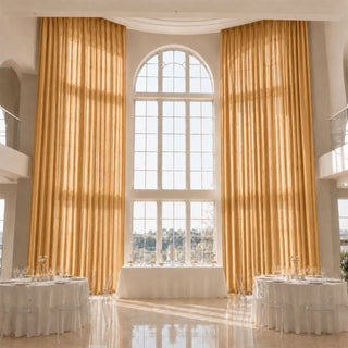 Elegant wedding reception with gold drapes and arched window ceremony backdrop
