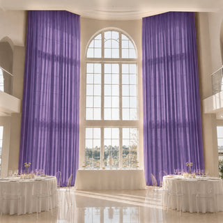 Elegant banquet hall with tall purple drapes and arched window decor