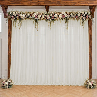Rustic wedding arch with white drapes and blush floral garland