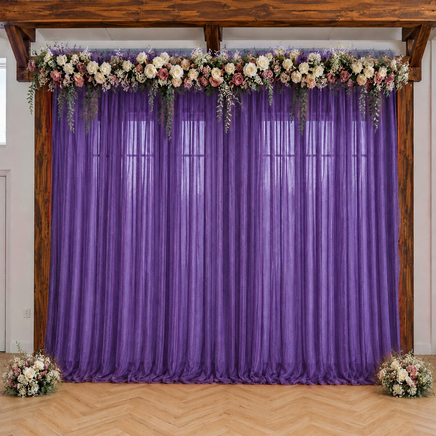 Purple wedding backdrop with floral garland and sheer curtains