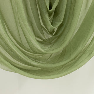 Green sheer fabric draped elegantly, showcasing its soft texture and flow.