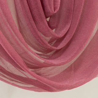 Pink sheer fabric draped elegantly in soft folds.