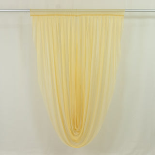 Pale yellow sheer curtain panel hanging on rod