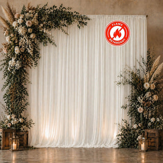 Floral wedding backdrop with white drapes and fire retardant label