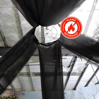 Flame retardant black fabric hanging from ceiling in a decorative setting.