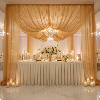 Elegant wedding reception setup with draped fabric, floral centerpieces, and soft lighting.