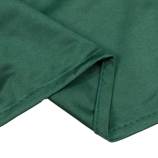 Green ribbed knit fabric close-up with folded hem detail