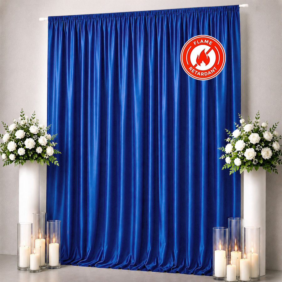Blue flame-retardant curtain backdrop with white floral arrangements and candles