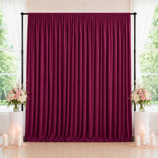 Elegant burgundy velvet backdrop with floral arrangements and candles