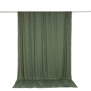 Olive green draped fabric backdrop with rod hanging on white background