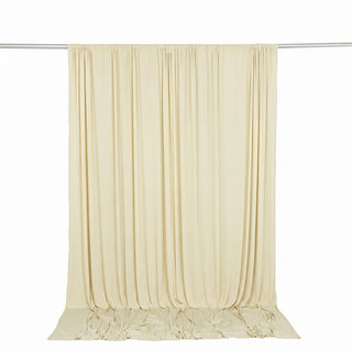 Cream sheer curtain panel hanging on a rod, elegant draped fabric backdrop