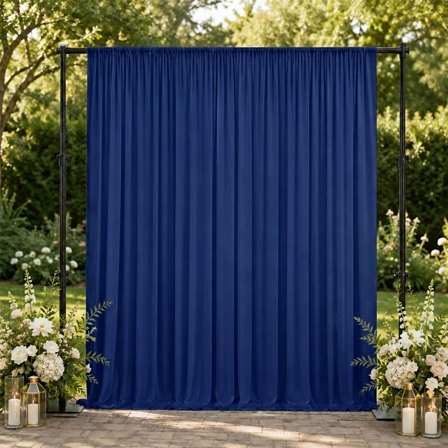 Blue wedding backdrop with floral arrangements and candles outdoors