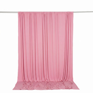 Pink sheer fabric curtain hanging on a rod, draped backdrop for photography