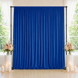 Blue wedding backdrop with floral arrangements and candles by windows