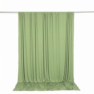 Light green draped fabric backdrop hanging on a studio rod