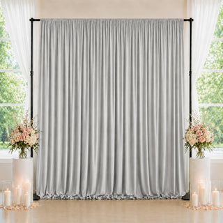 Elegant silver backdrop curtain with floral arrangements and candles for events