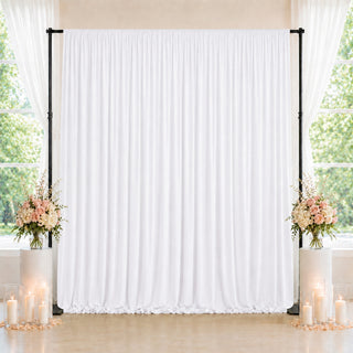 Elegant white wedding backdrop with floral arrangements and candles