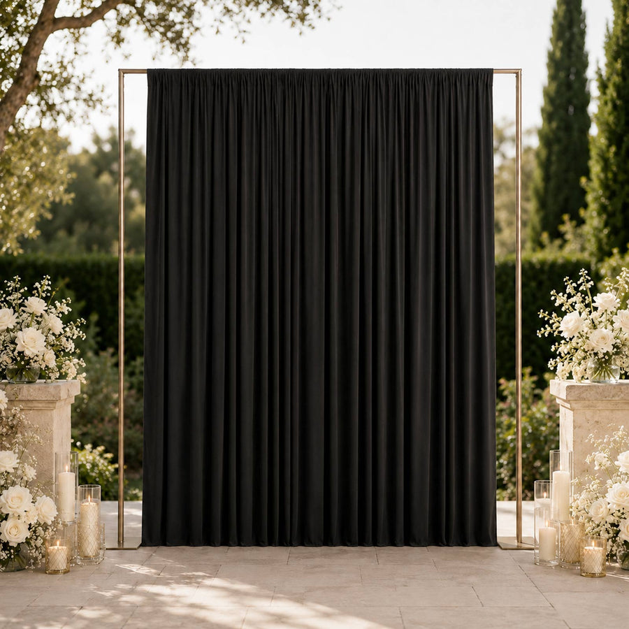 Elegant black wedding backdrop with white floral arrangements outdoors