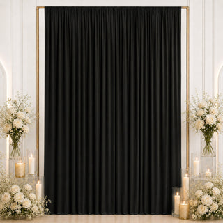 Elegant black curtain backdrop with white floral arrangements and candles