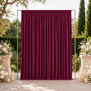 Elegant burgundy wedding backdrop with floral arrangements and candles