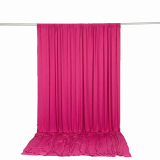 Hot pink draped fabric backdrop with floor pooling on a hanging rod