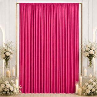 Pink satin backdrop with white floral arrangements and candles for event decor
