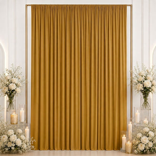 Gold wedding backdrop curtain with white floral arrangements and candles