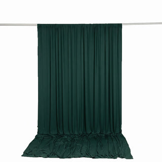 Dark green curtain draped on rod against white background