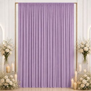 Lavender draped backdrop with white floral arrangements and candles