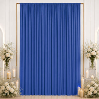 Blue event backdrop curtain with white floral candle decor on both sides