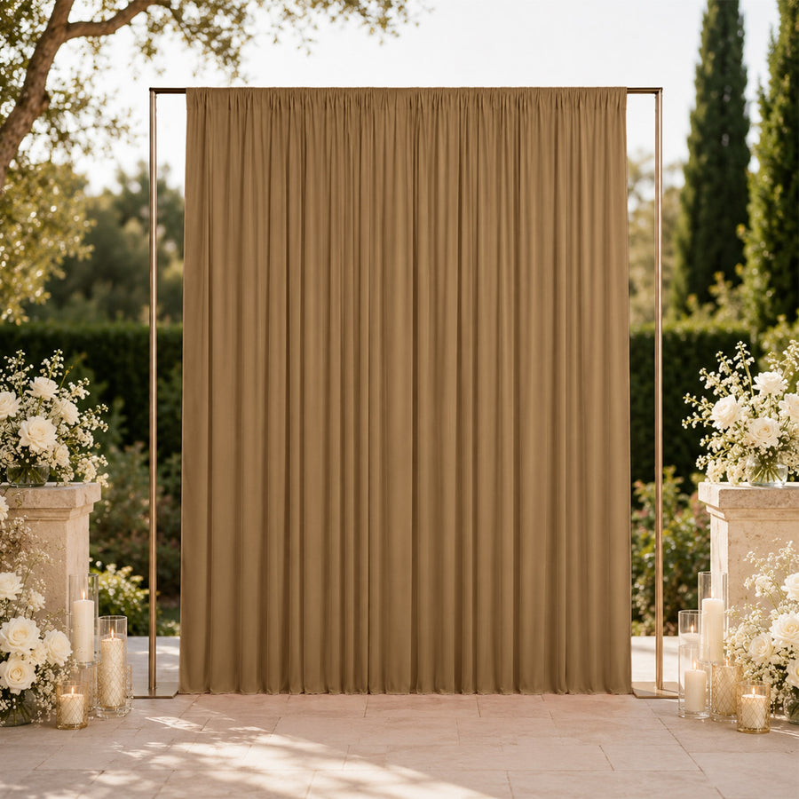 Elegant outdoor wedding backdrop with gold drape and white floral arrangements