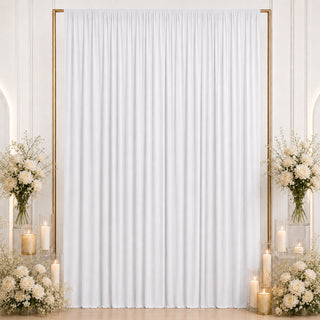 Elegant white wedding backdrop with gold frame, candles, and floral arrangements